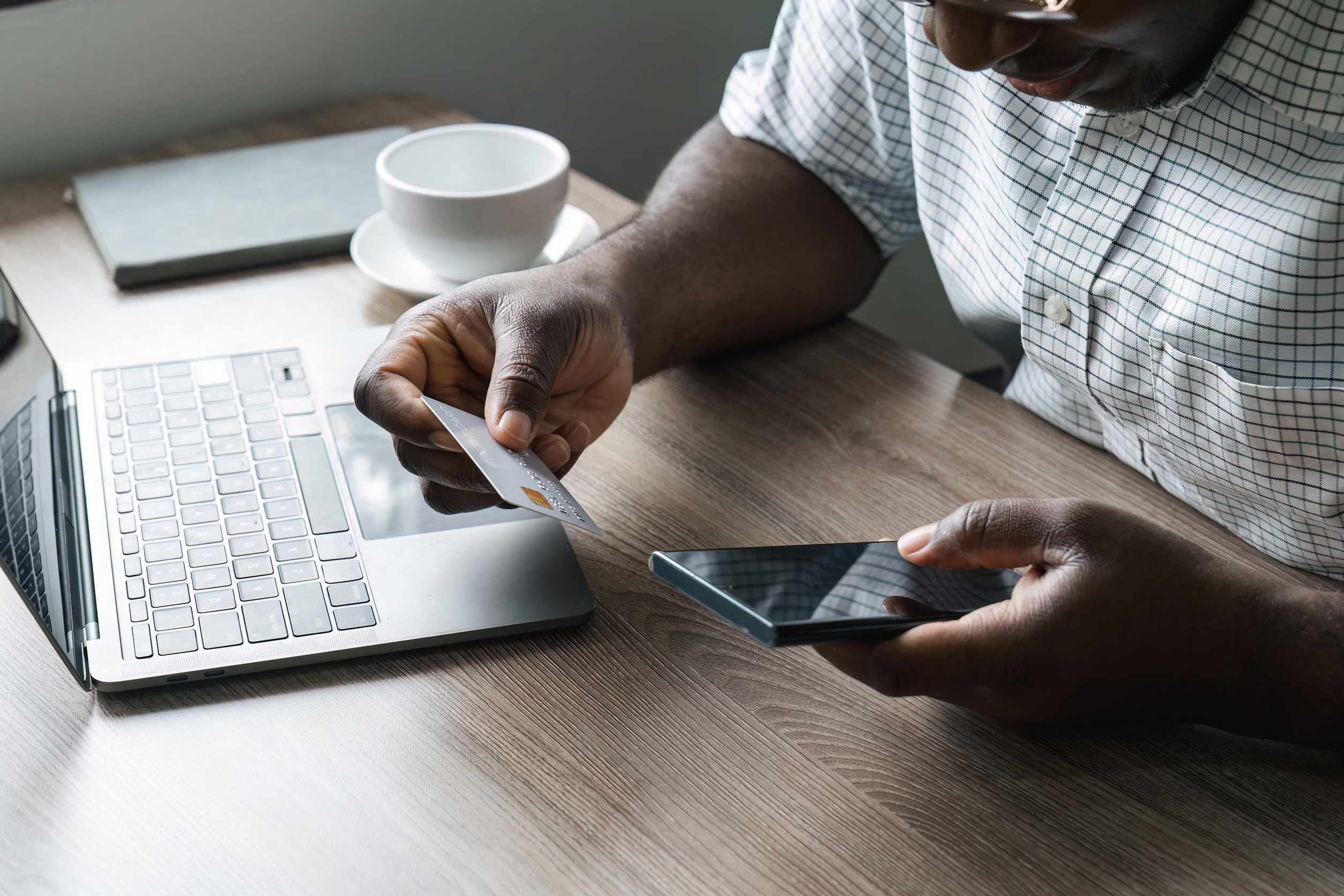 A Man Using A Card To Pay Online